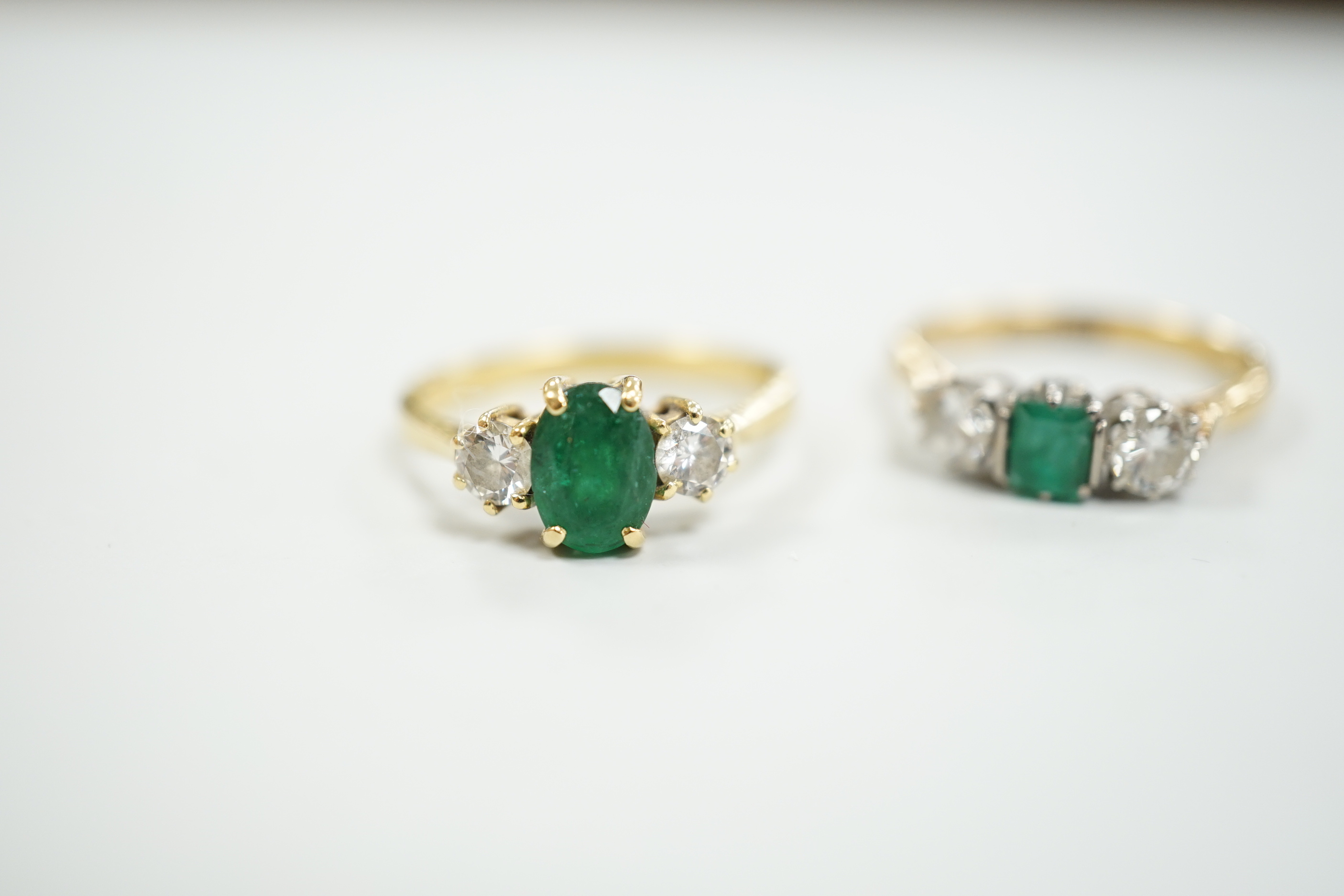 Two 18ct, single stone emerald and two stone diamond set rings, size M, gross weight, 5.5 grams.